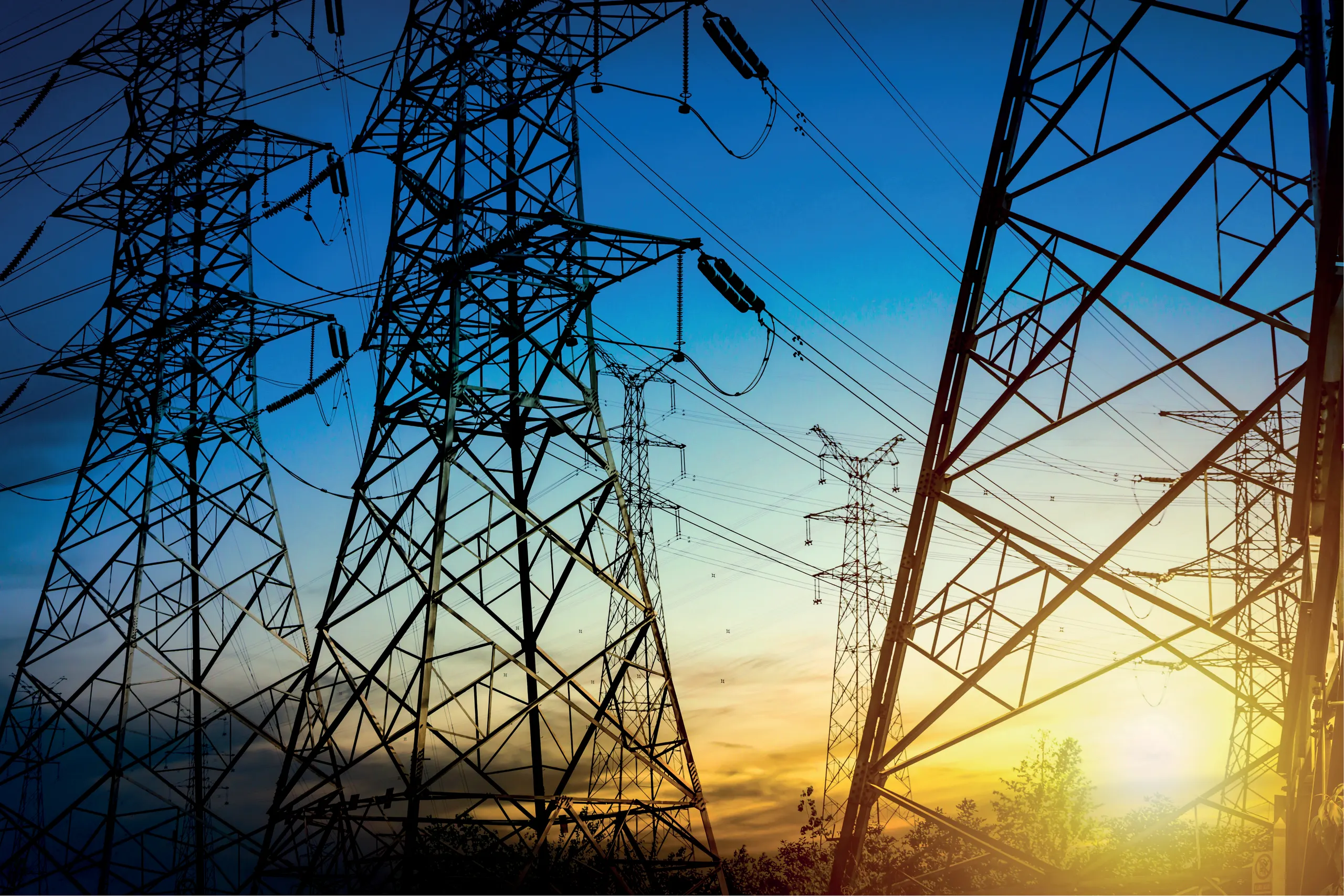 High-voltage power pylons at sunset